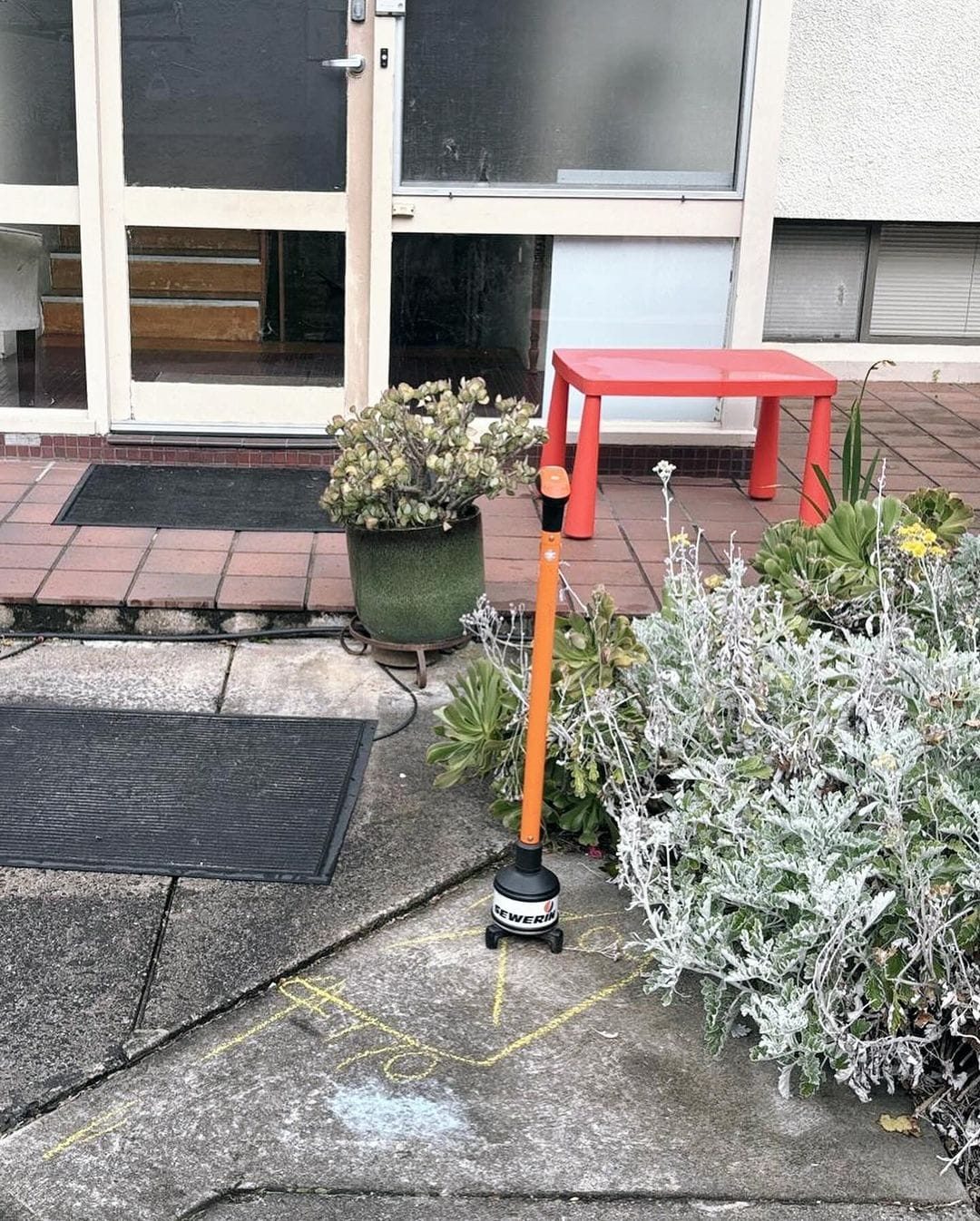 Geofone posicionado sobre o piso externo, ao lado de marcações de giz